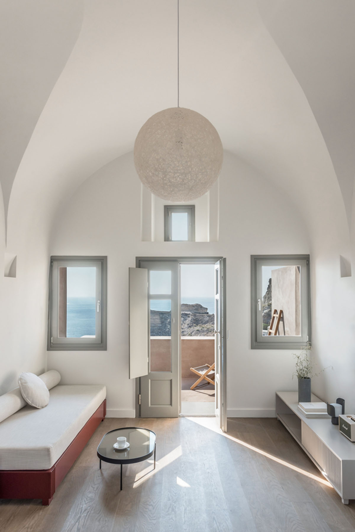 Kapsimalis Architects built castle-like hotel almost disappearing it on a steep hillside of Oia