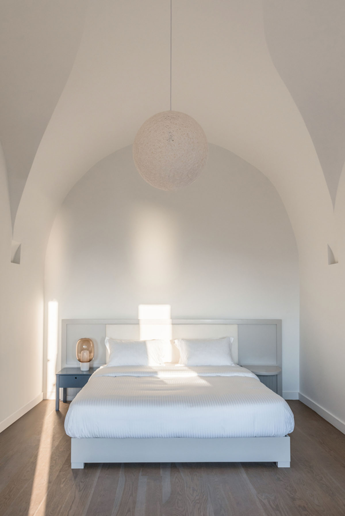 Kapsimalis Architects built castle-like hotel almost disappearing it on a steep hillside of Oia