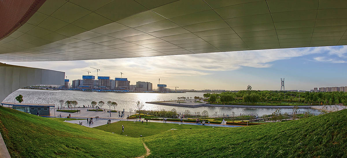 STUDIO A+ designs climbable ring-shaped art center on a green mound in Zhengzhou