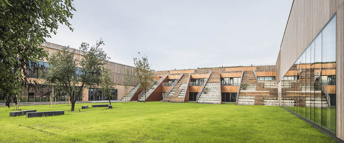 Huge tribunes invite students to sit and experience the courtyard in Warsaw's Akademeia High School