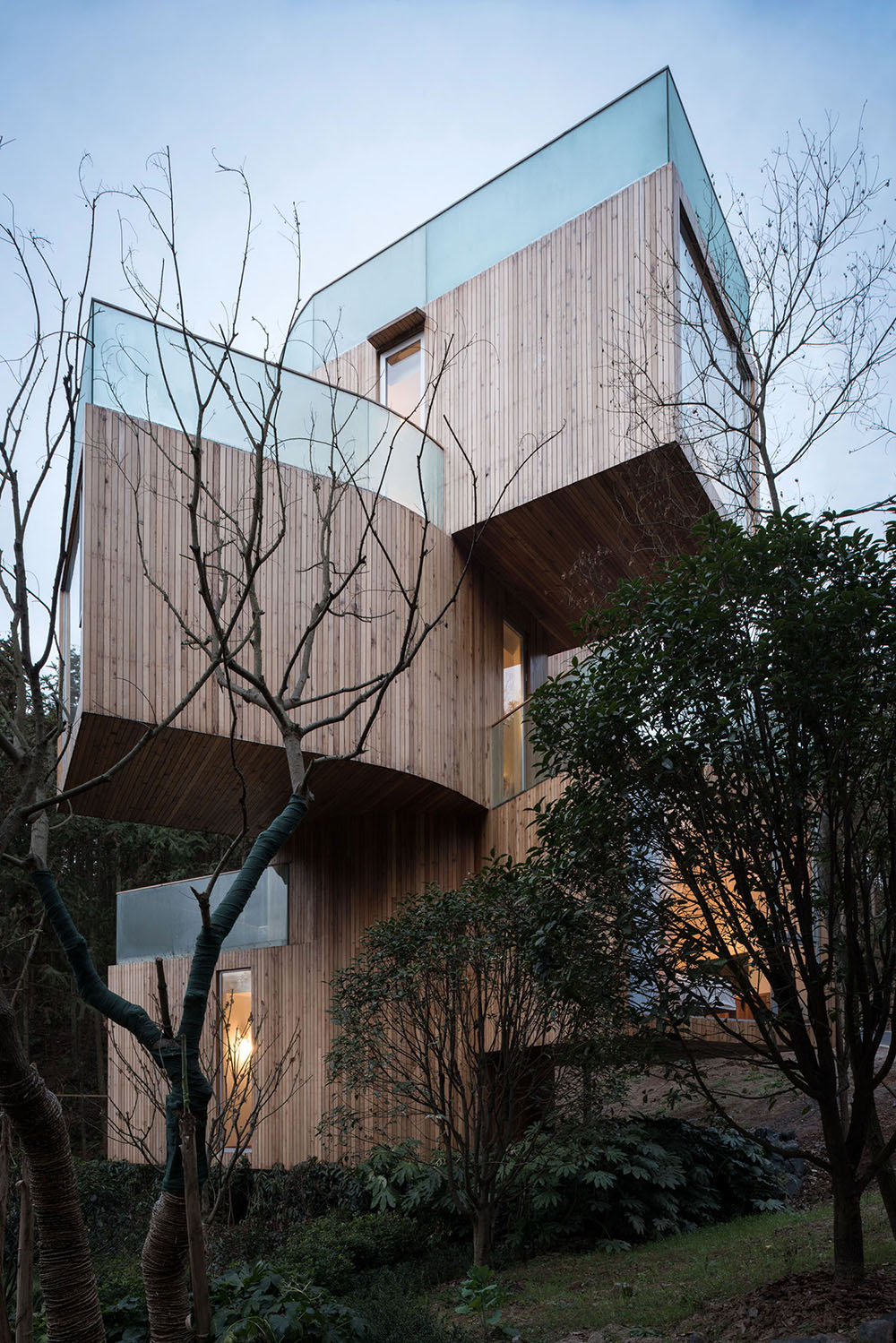 Bengo Studio joints multiple wooden rooms around a central staircase for Qiyun Mountain Tree Hotel