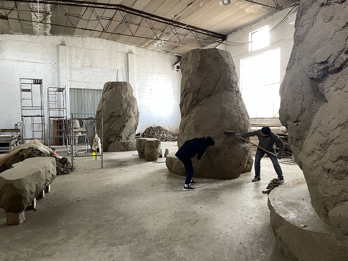 B.L.U.E. Architecture Studio adds a glazed cafe by using organic forms of stones to an open plaza