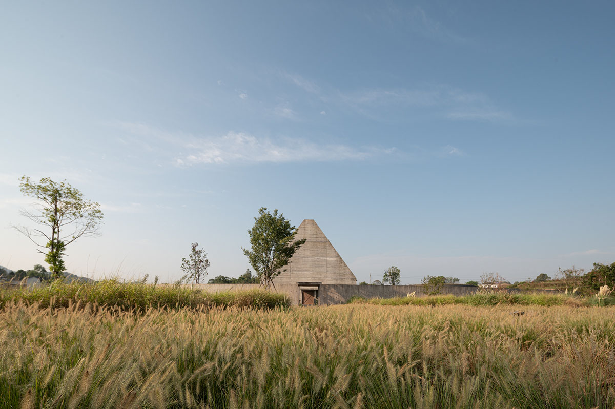 Concrete Land Museum made of pitched roof overlooks sorghum fields on Island Hopping Village