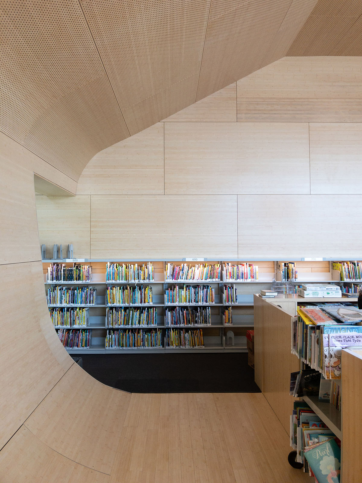 Steven Holl Architects completes Hunters Point Library with flowing sculpted cuts in New York