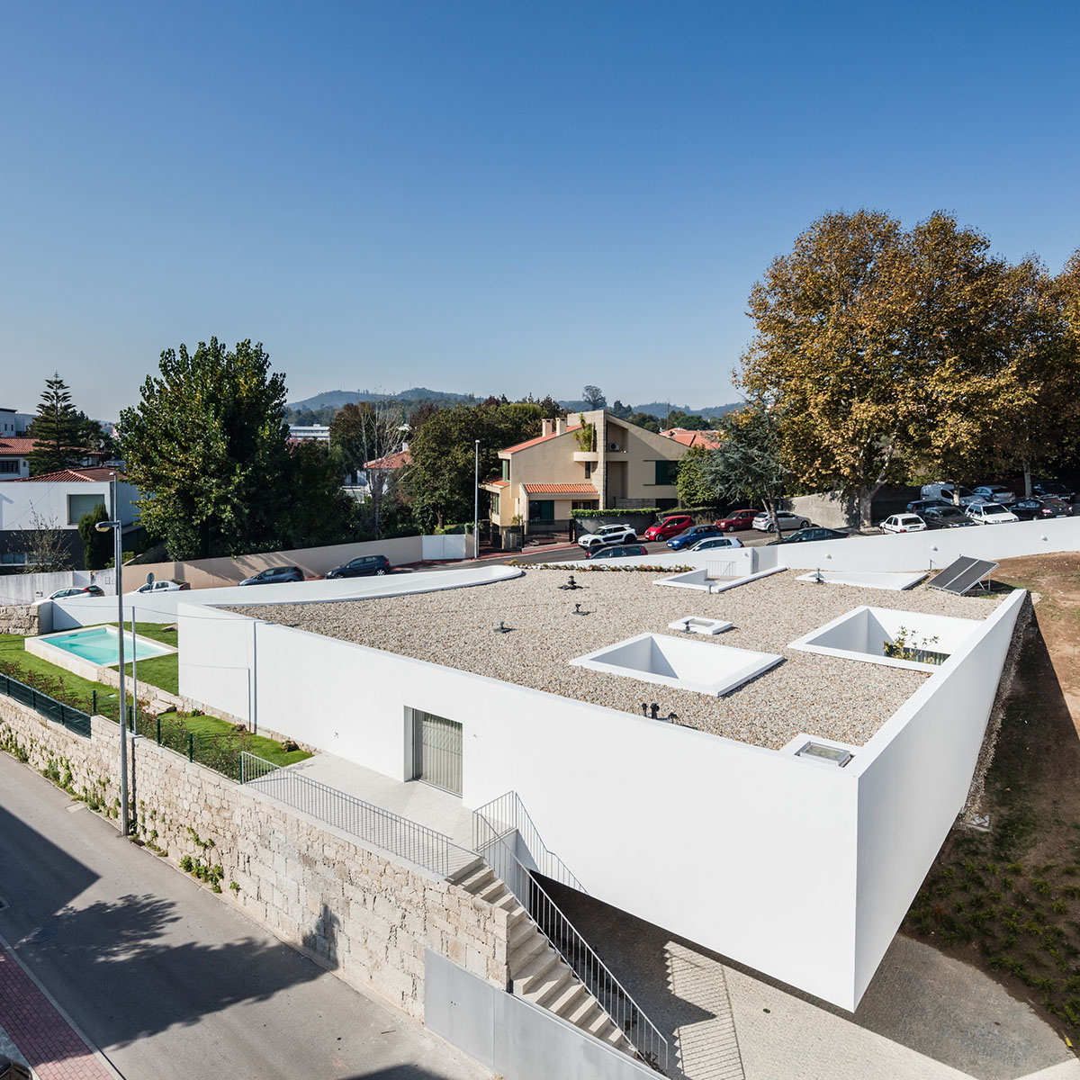 NOARQ designs smooth curvy-roof for Portuguese house to adapt to topography and create courtyards