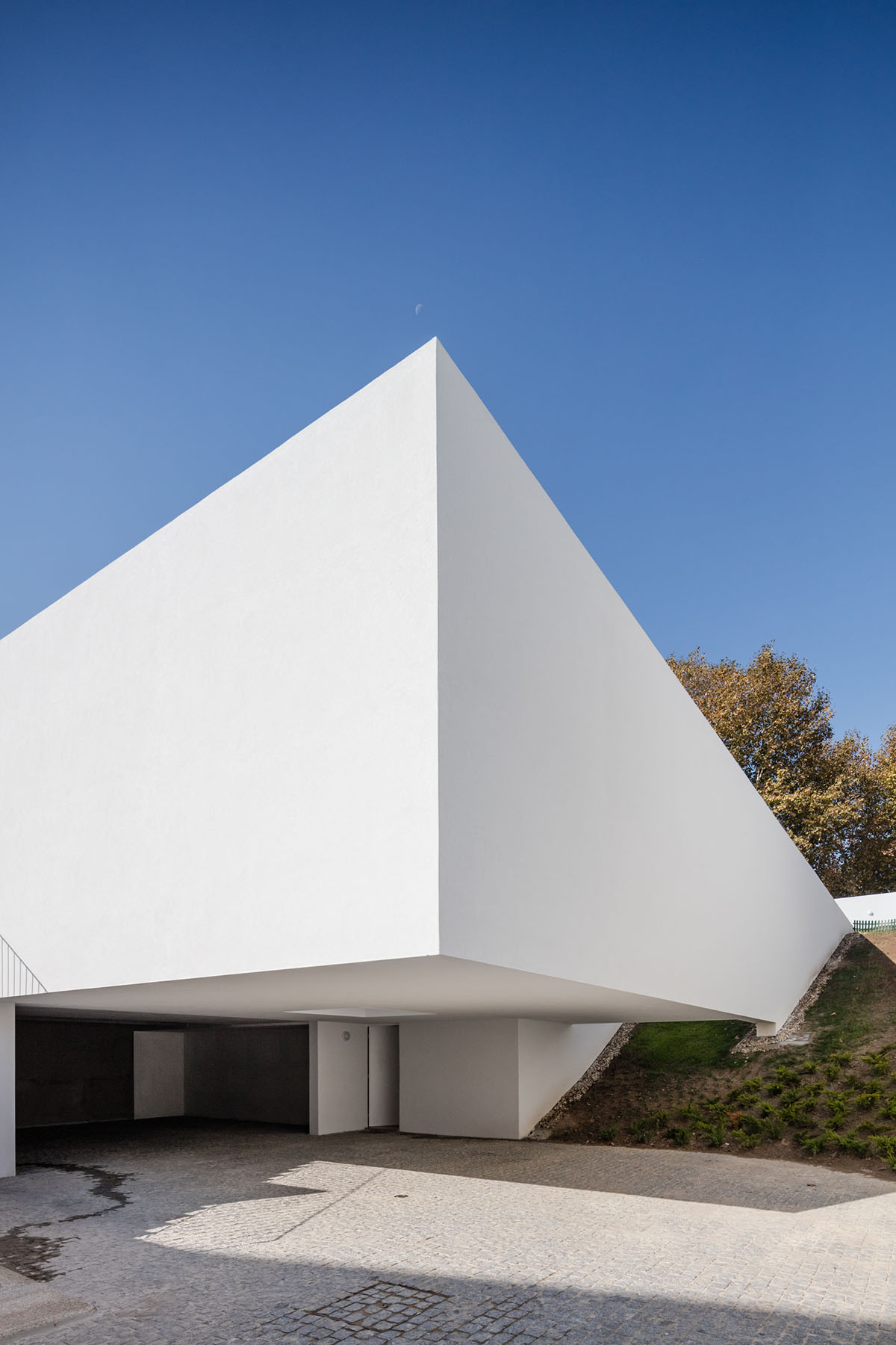 NOARQ designs smooth curvy-roof for Portuguese house to adapt to topography and create courtyards