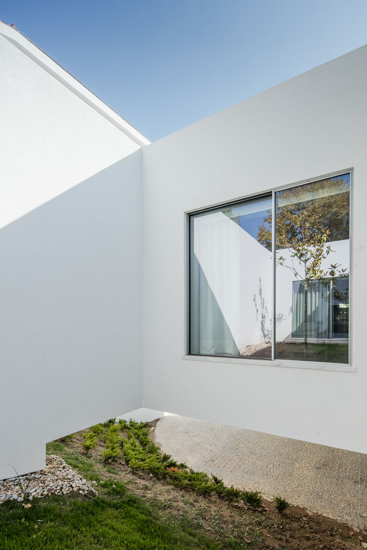NOARQ designs smooth curvy-roof for Portuguese house to adapt to topography and create courtyards