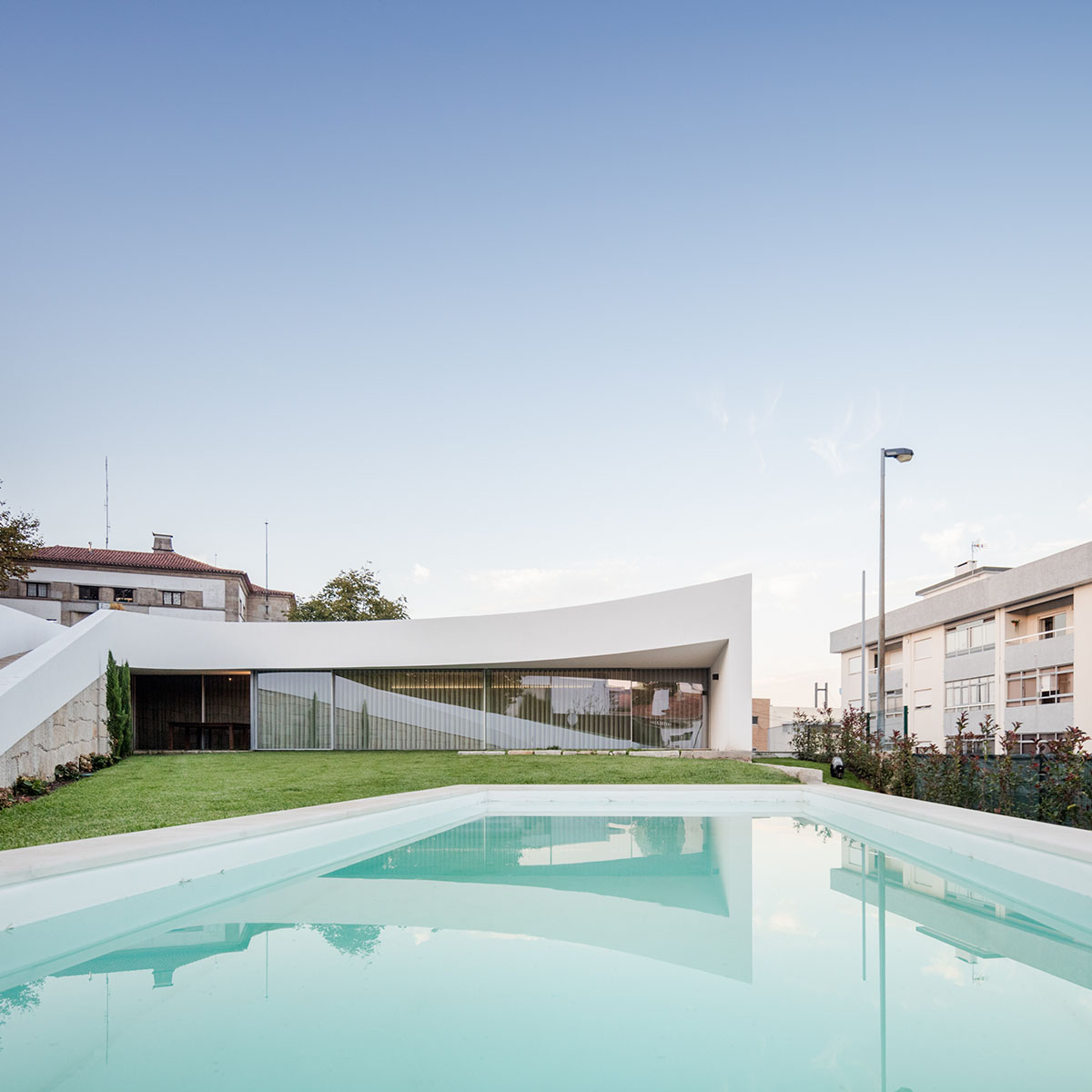 NOARQ designs smooth curvy-roof for Portuguese house to adapt to topography and create courtyards