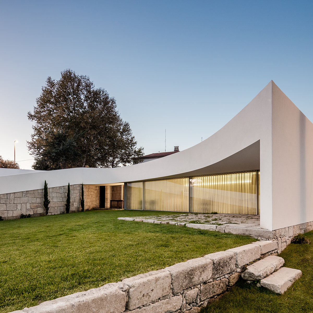NOARQ designs smooth curvy-roof for Portuguese house to adapt to topography and create courtyards