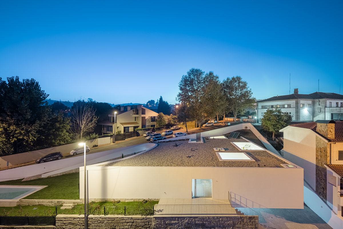 NOARQ designs smooth curvy-roof for Portuguese house to adapt to topography and create courtyards