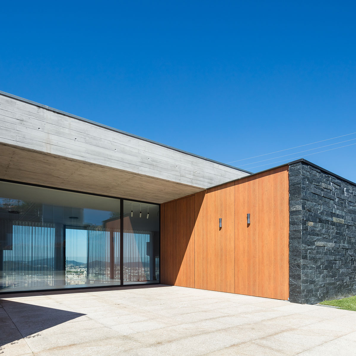 TRAMA Arquitetos completes v-shaped concrete house on hillside of Braga