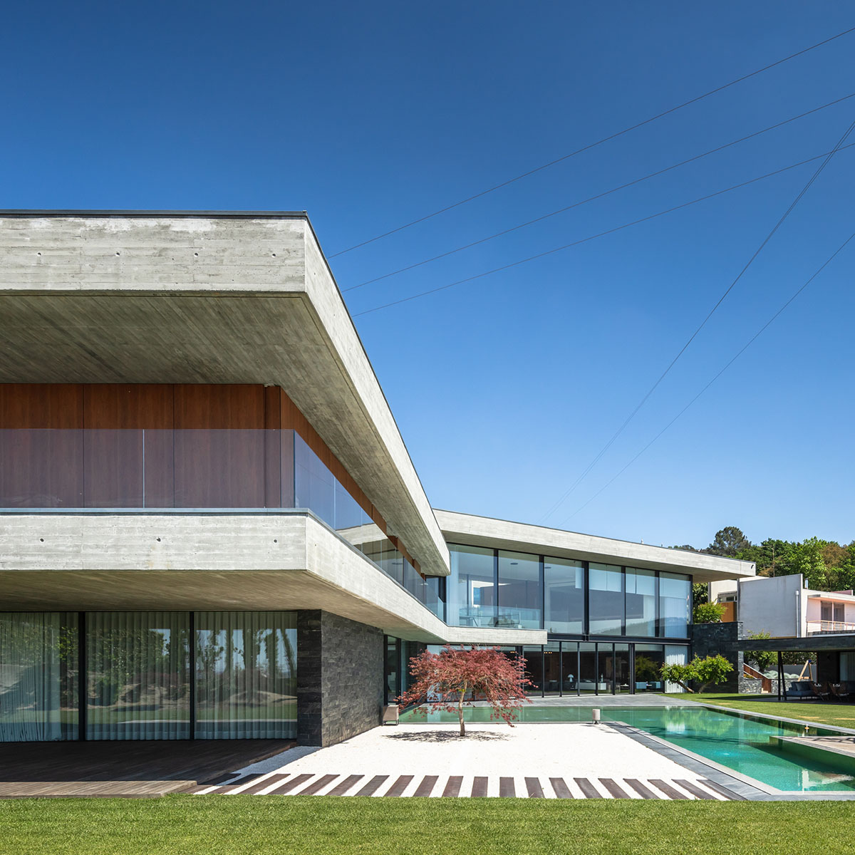 TRAMA Arquitetos completes v-shaped concrete house on hillside of Braga