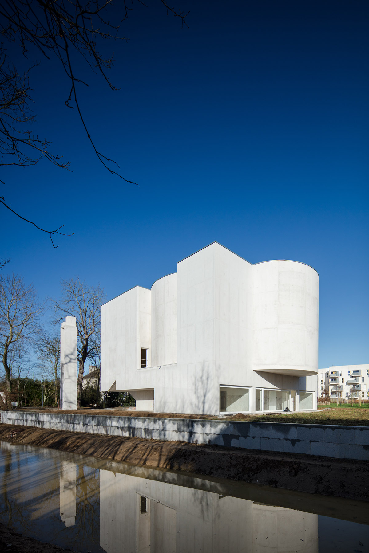 Álvaro Siza Completes His First Church In France with white coloured interlocking concrete volumes