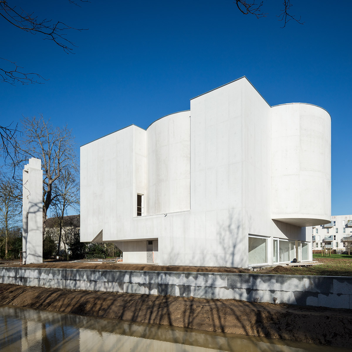 Álvaro Siza Completes His First Church In France with white coloured interlocking concrete volumes
