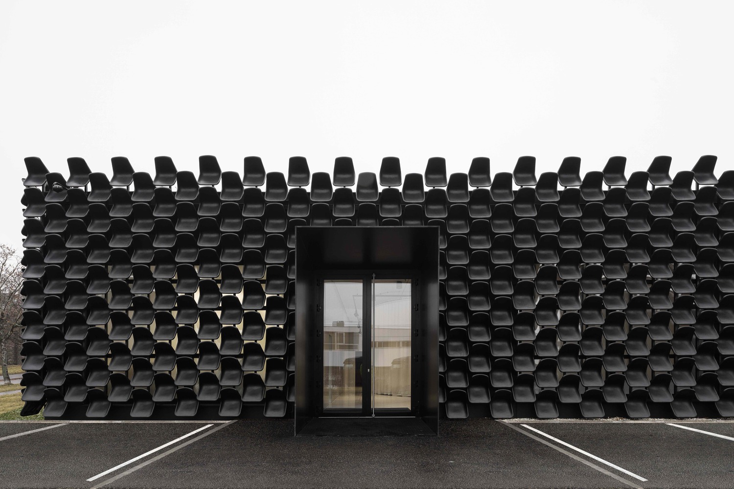 Architects use more than 900 black plastic seats for a gallery to create easily remembered building