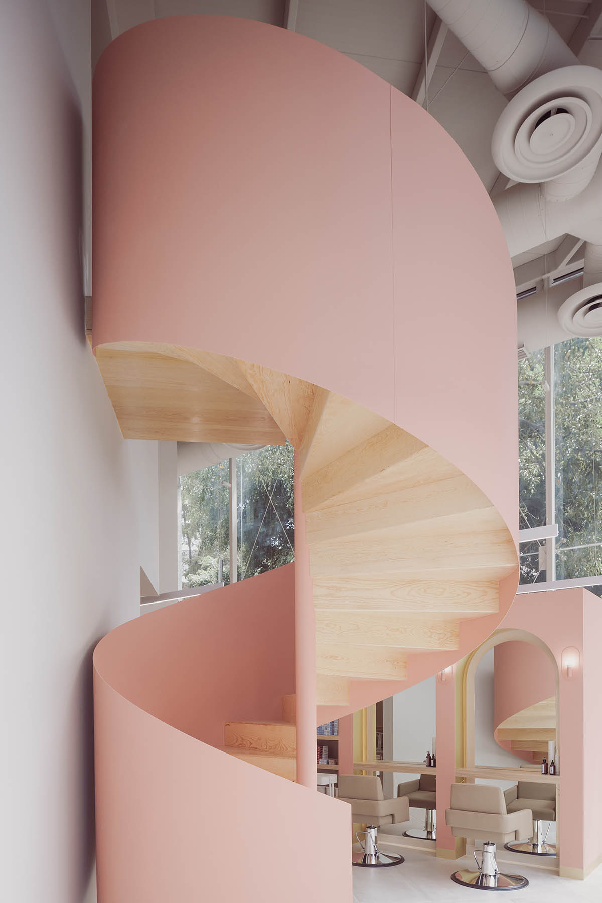 VOID Studio amplifies the mechanism of work with soft pinkish staircase and cabin-like stations
