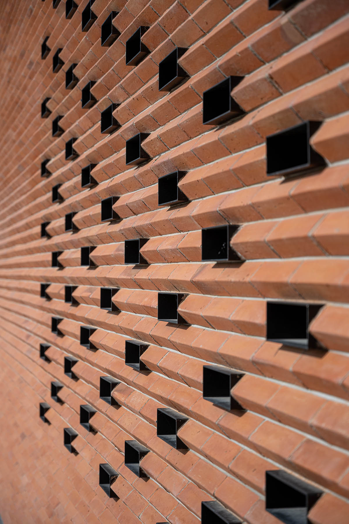 PHTAA living design completes Lorpoonphol Rice Mill Office featuring zig-zag brick wall in Thailand