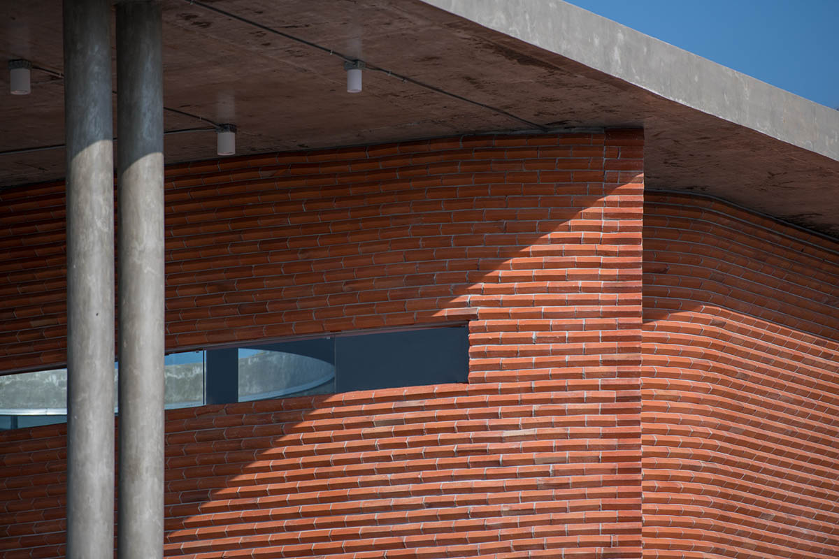 PHTAA living design completes Lorpoonphol Rice Mill Office featuring zig-zag brick wall in Thailand