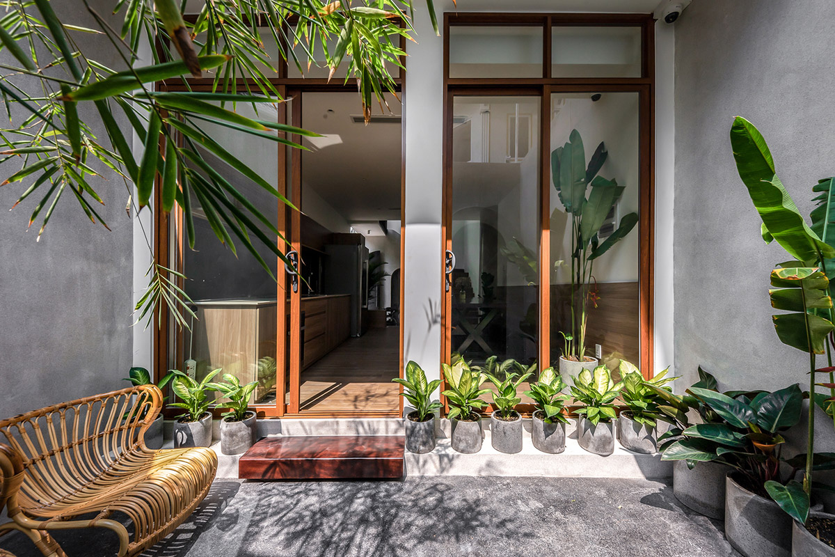 Vertical glass array cuts façade of this L-shaped concrete house ...