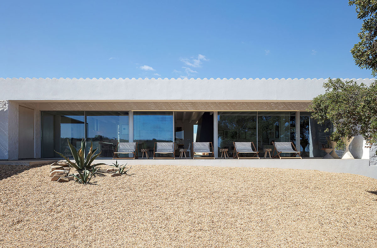 Low-profiled whitewashed stone walls wrap living units of Casa da Volta by PROMONTORIO and João Cravo