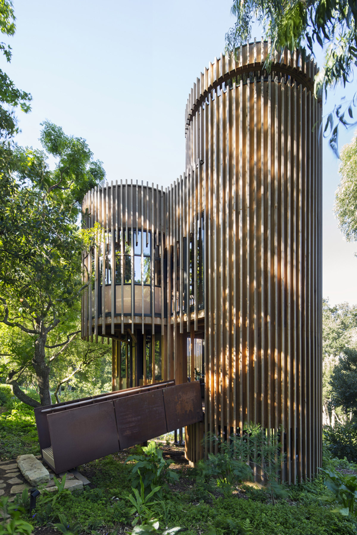 Circular tree house is raised over slender stilts to dominate the forest in every direction
