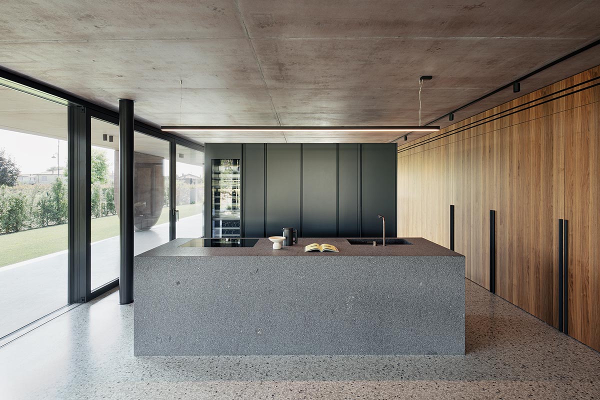 Red pigmented house by MIDE architetti features a large porch profiled by geometrical openings 