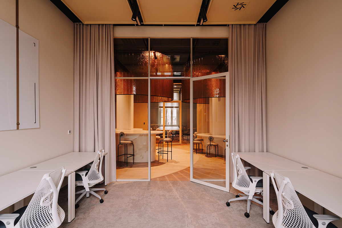 This copper-hued co-working space interior is designed to inspire creative work in Wrocław