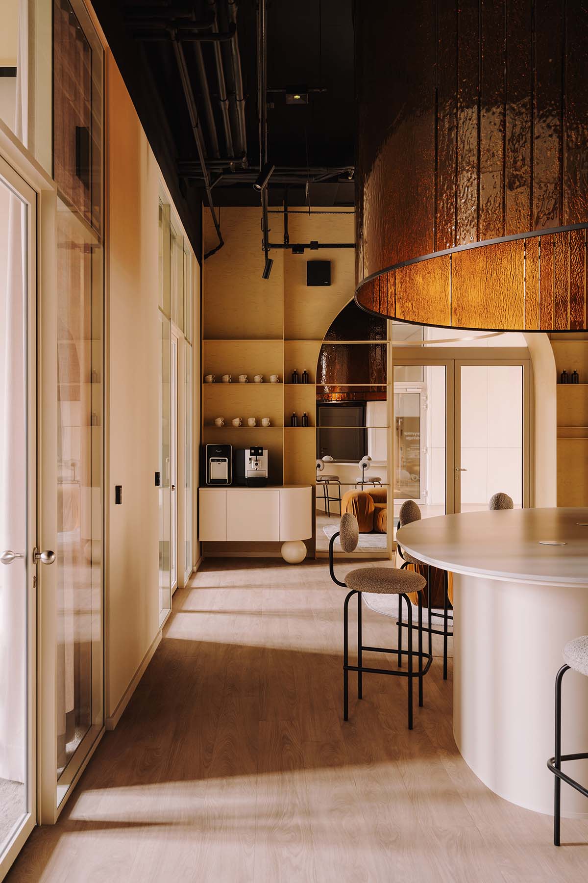 This copper-hued co-working space interior is designed to inspire creative work in Wrocław