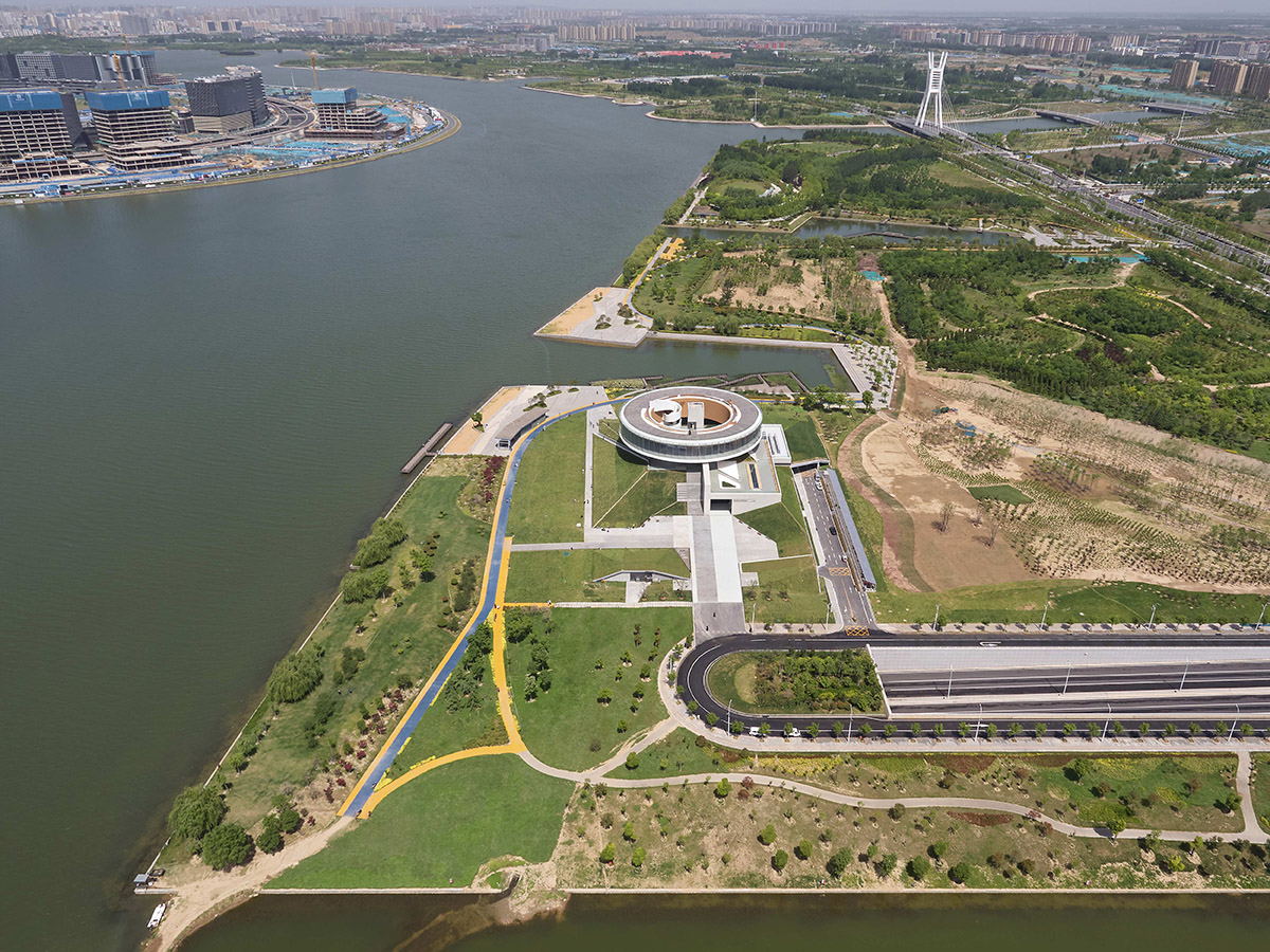 STUDIO A+ designs climbable ring-shaped art center on a green mound in Zhengzhou