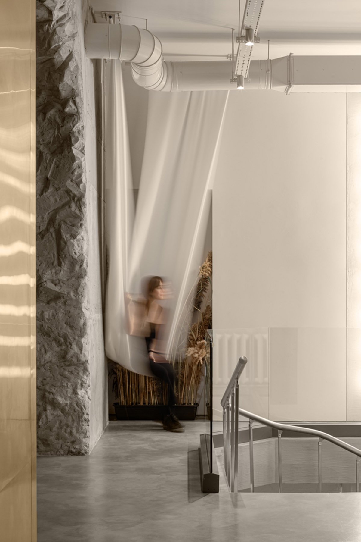 Cast-in-situ concrete, golden panels, metallic curtains soften beauty salon designed by balbek bureau