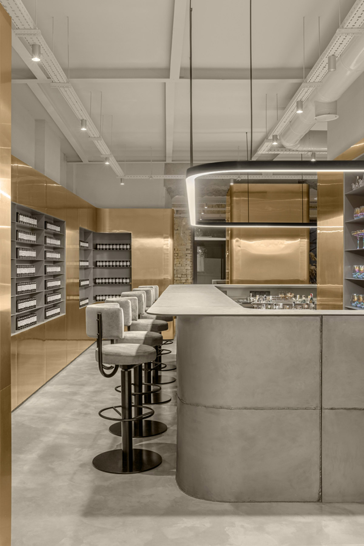 Cast-in-situ concrete, golden panels, metallic curtains soften beauty salon designed by balbek bureau