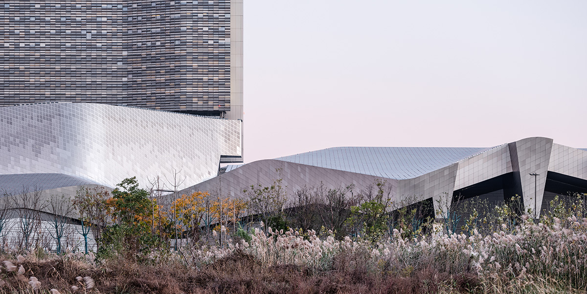 Morphosis designs conference center featuring undulating podium clad in titanium panels in China 