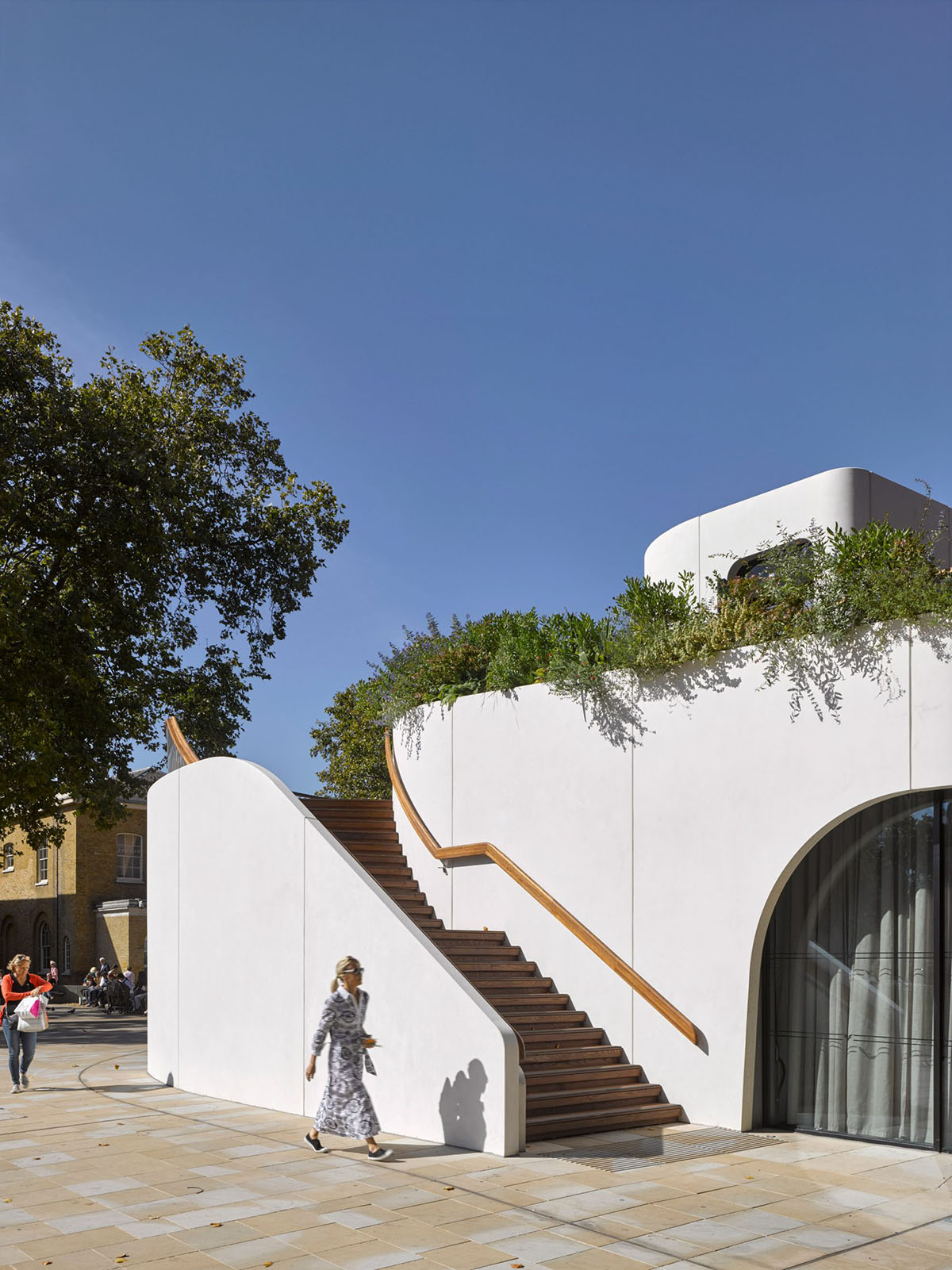 NEX designed restaurant with spiralling concrete wall and retractable curved glass system in London