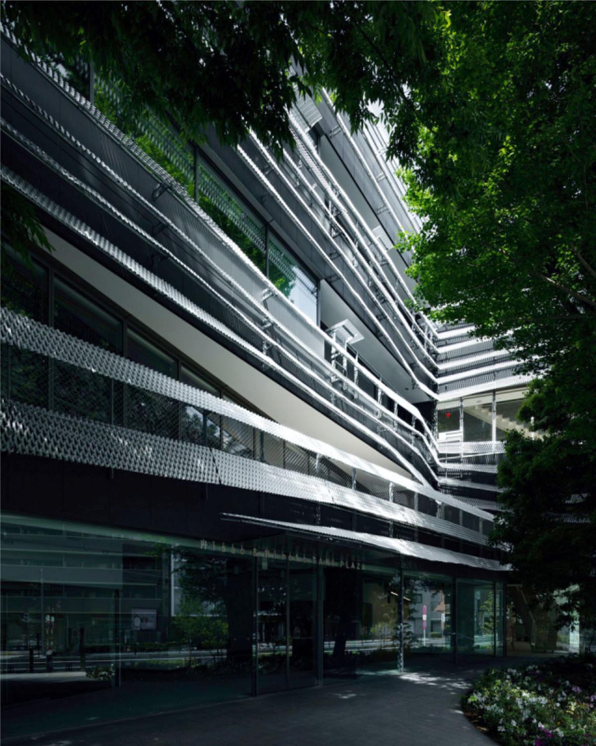 Kengo Kuma wraps alumni building in Tokyo with irregular metal surface creating organic skin