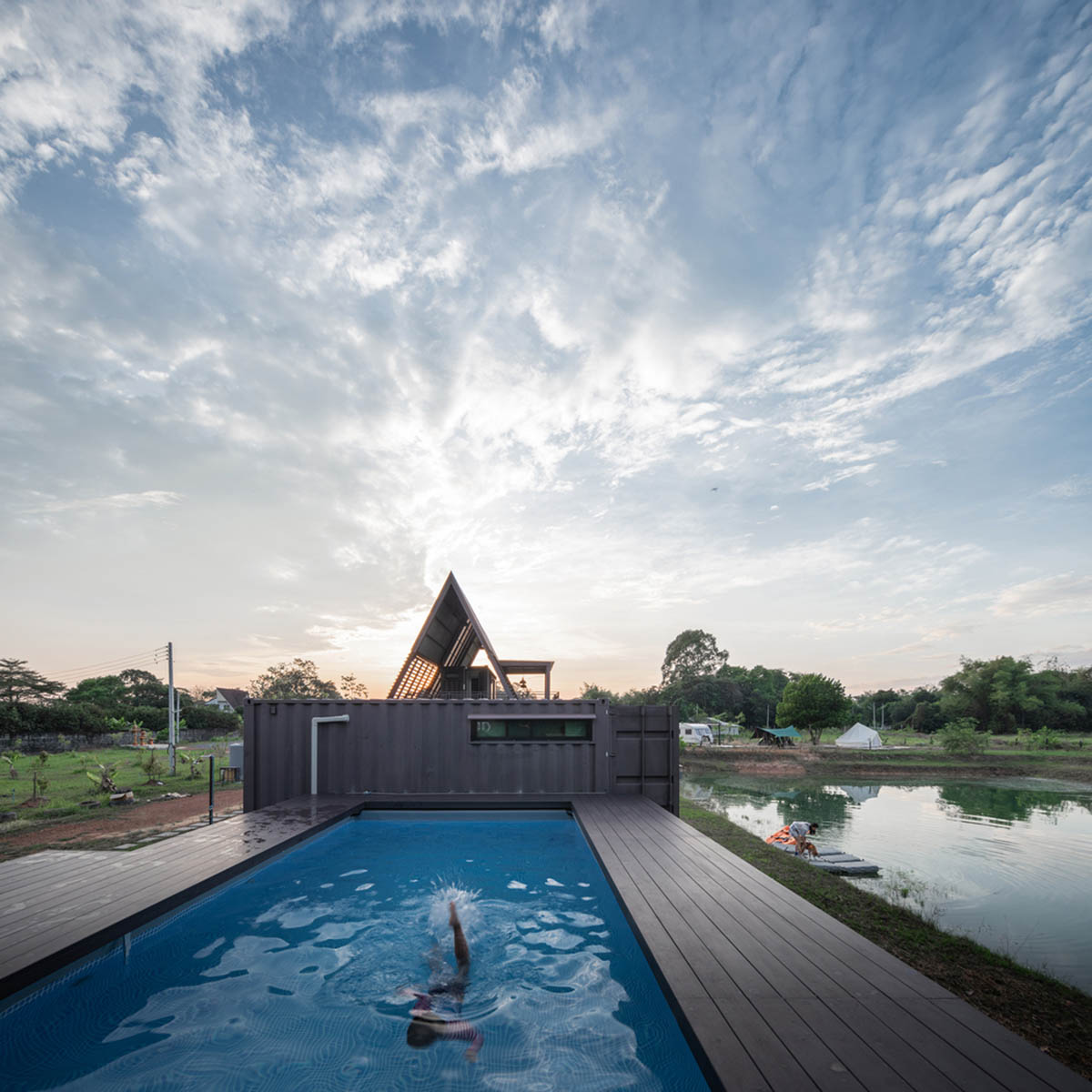 Disused shipping containers form a holiday home under A-frame roof by Tung Jai Ork Baab