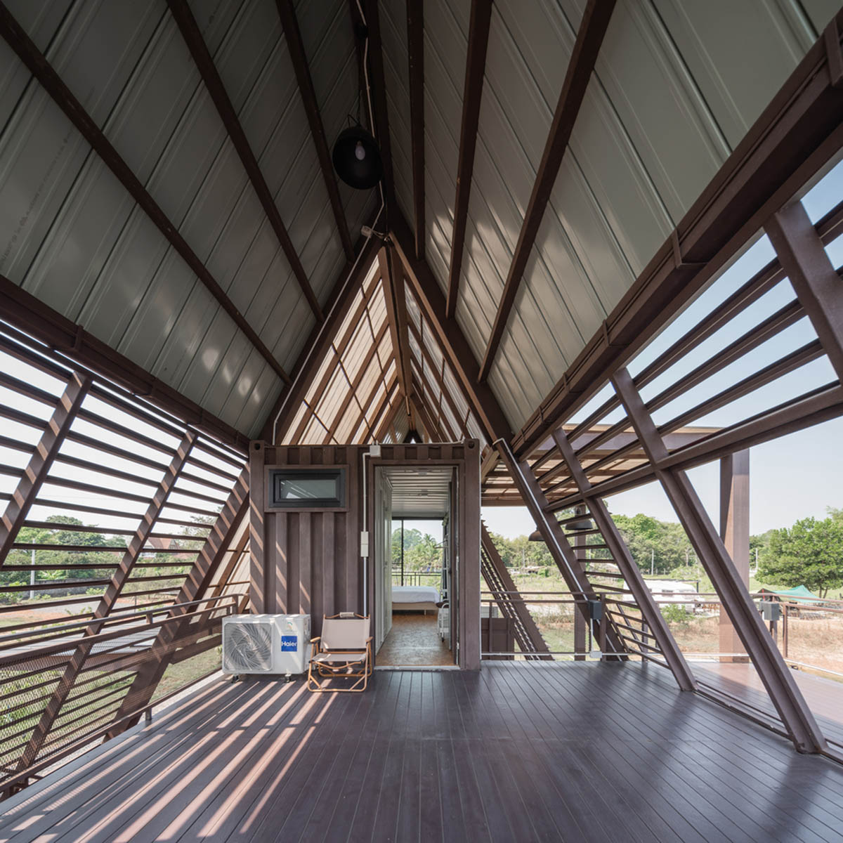 Disused shipping containers form a holiday home under A-frame roof by Tung Jai Ork Baab