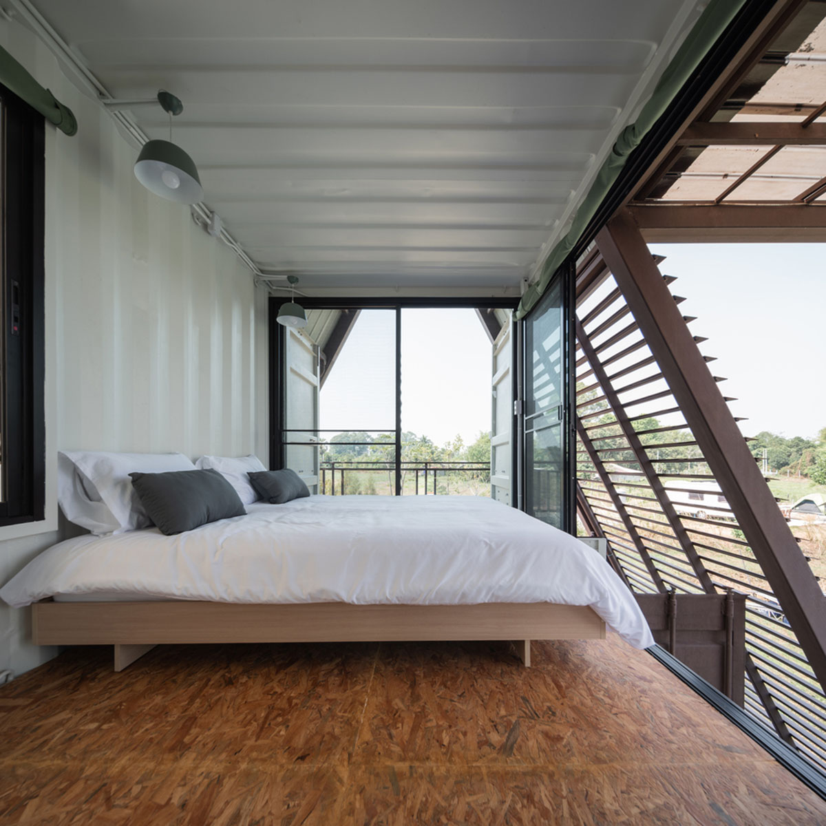 Disused shipping containers form a holiday home under A-frame roof by Tung Jai Ork Baab
