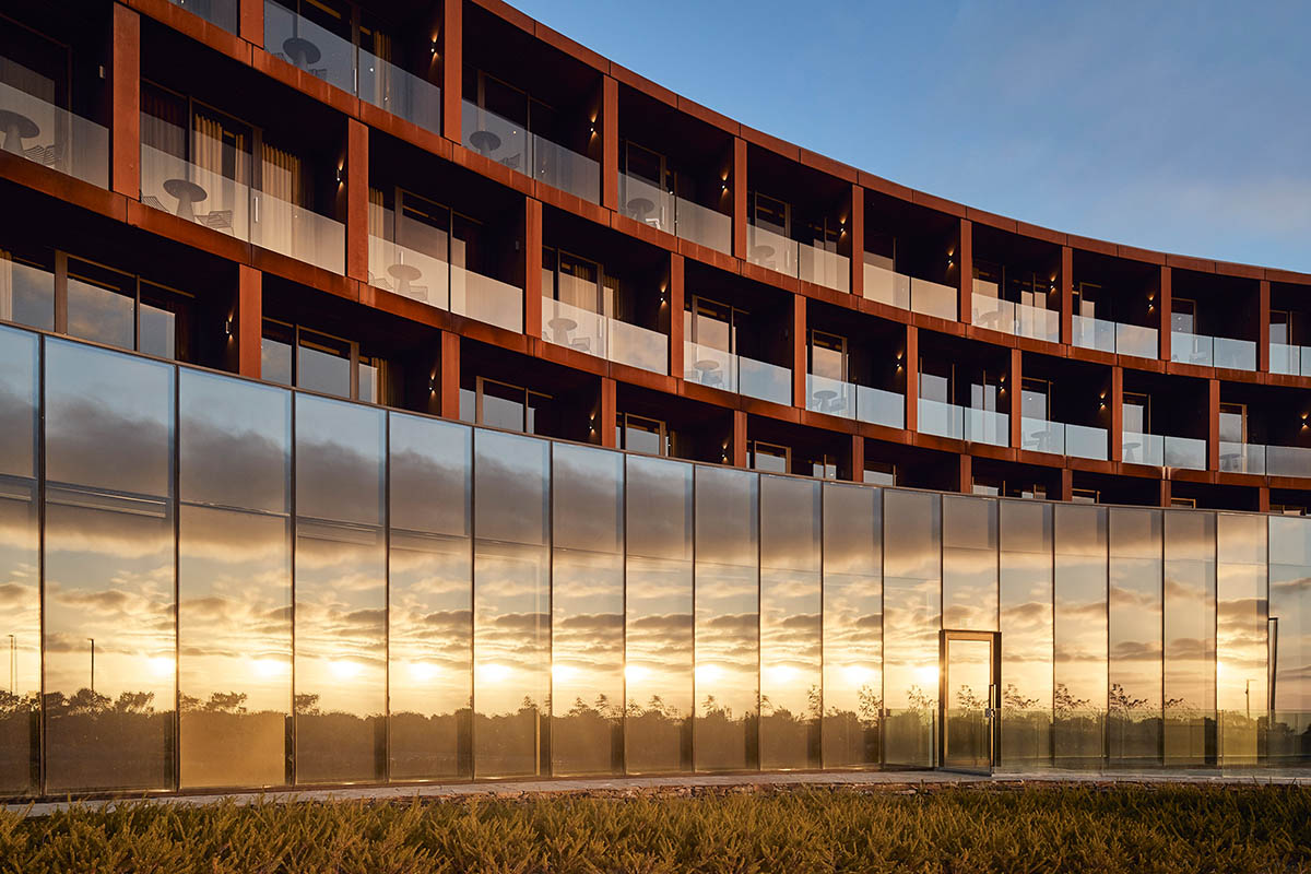 Wood Marsh completes sinuous resort anchored on hand-built locally sourced stone plinth in Australia