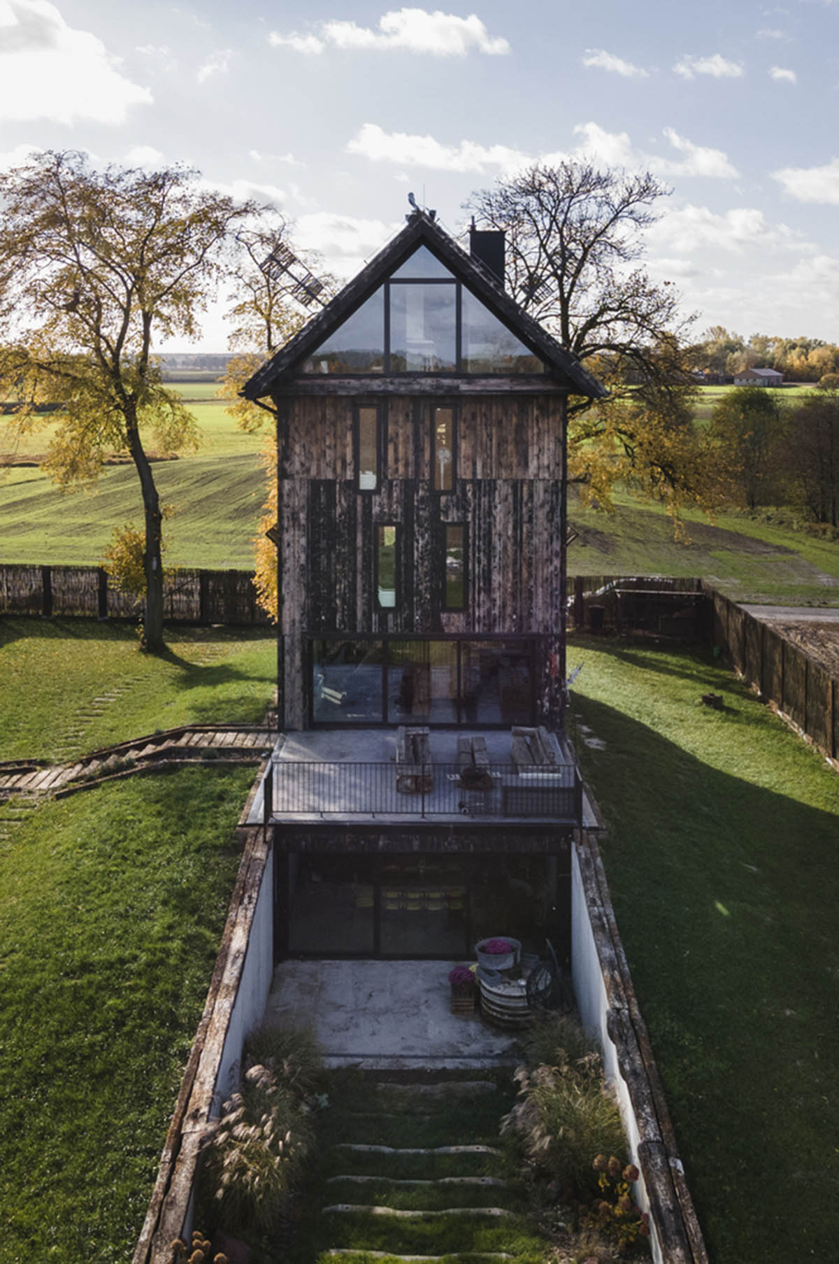 Michał Kucharski and o4 architekci clad old windmill with charred wood in a Polish town 