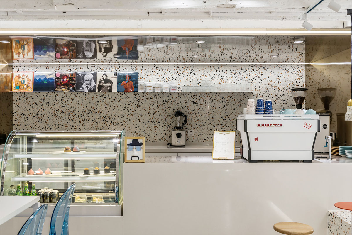 This tiny cafe by TOUCH Design is dotted with white and orange interwoven terrazzo details in Tianjin
