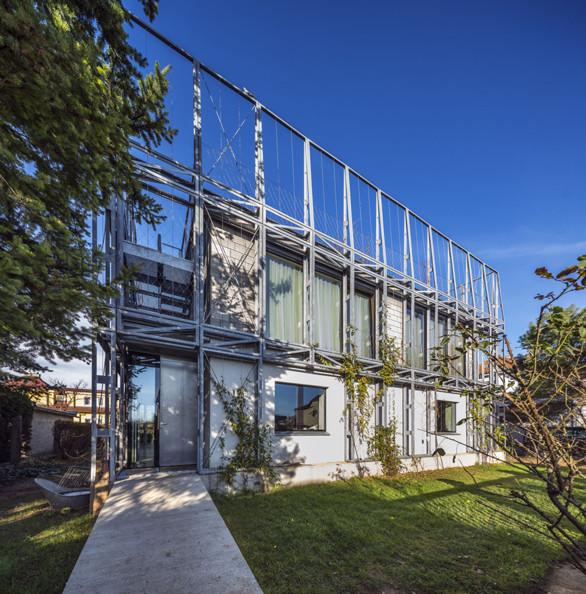ŠÉPKA Architects wraps old residence with steel lattice featuring climbing plants as facade element