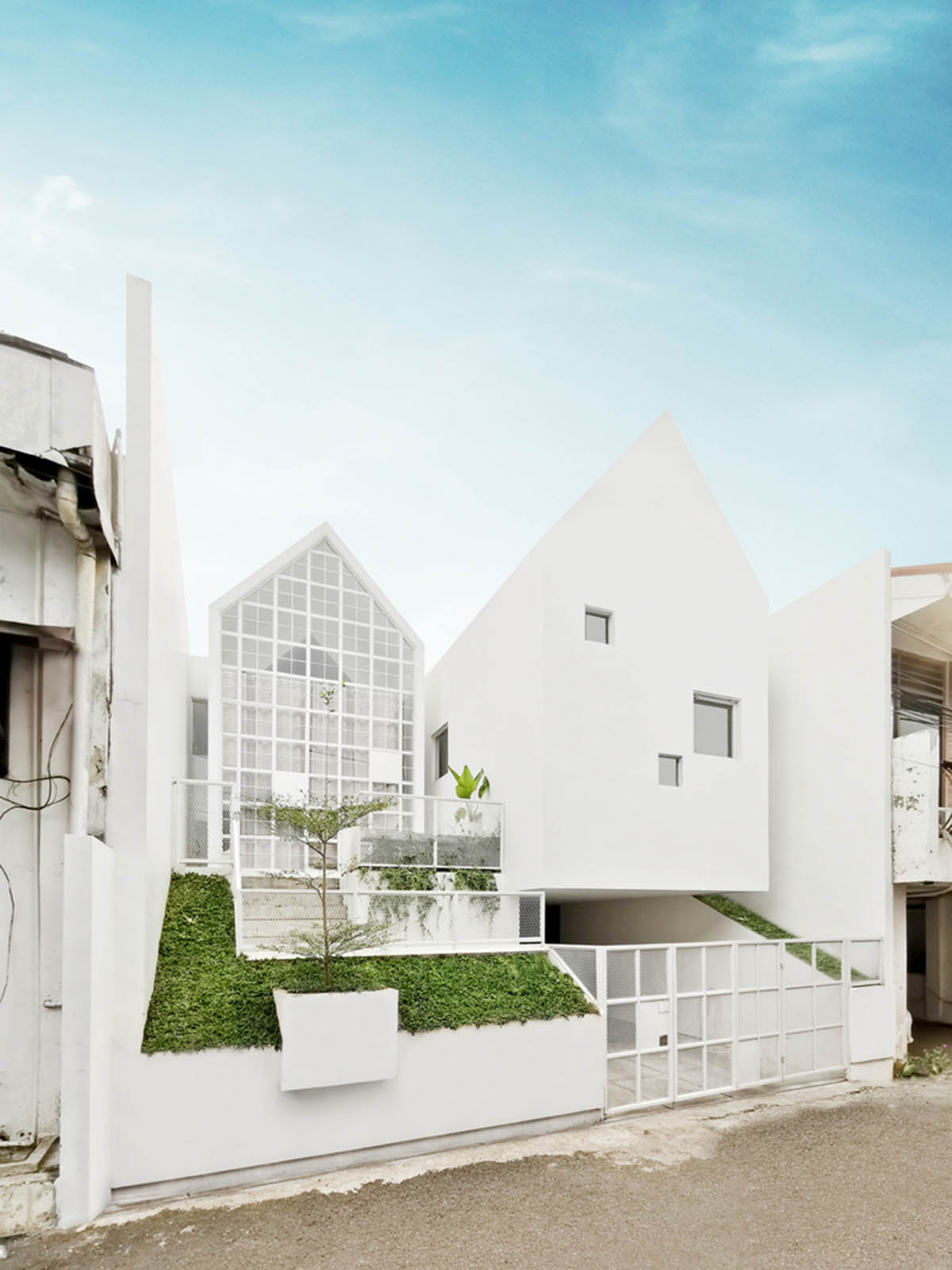 Semiotic Arsitek designs white UR House with saddle roofs in Jakarta