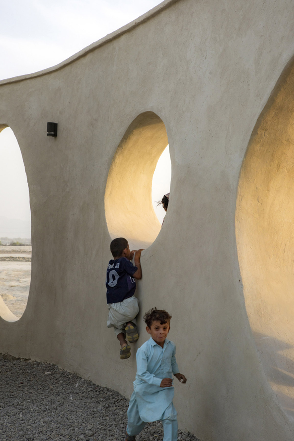 Circular wall featuring inhabitable holes encapsulates elementary school designed by Daaz Office