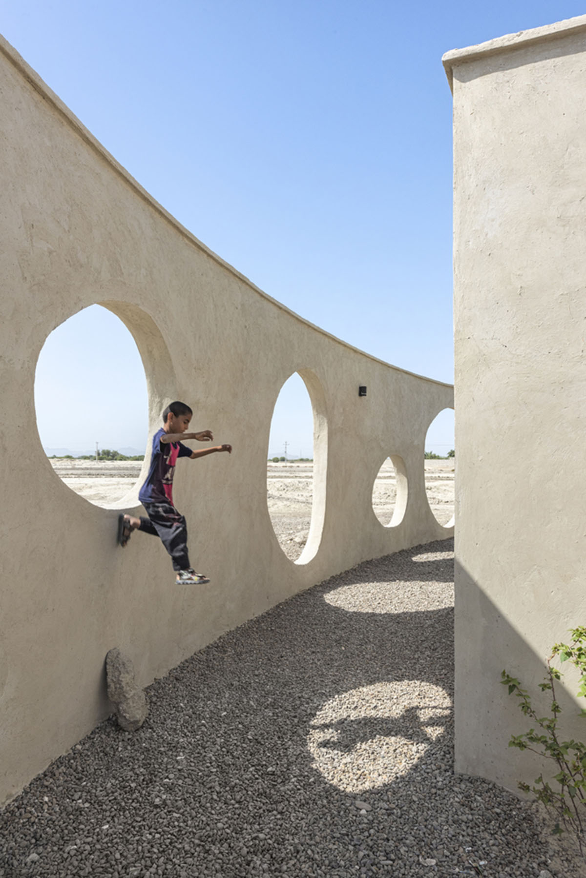 Circular wall featuring inhabitable holes encapsulates elementary school designed by Daaz Office
