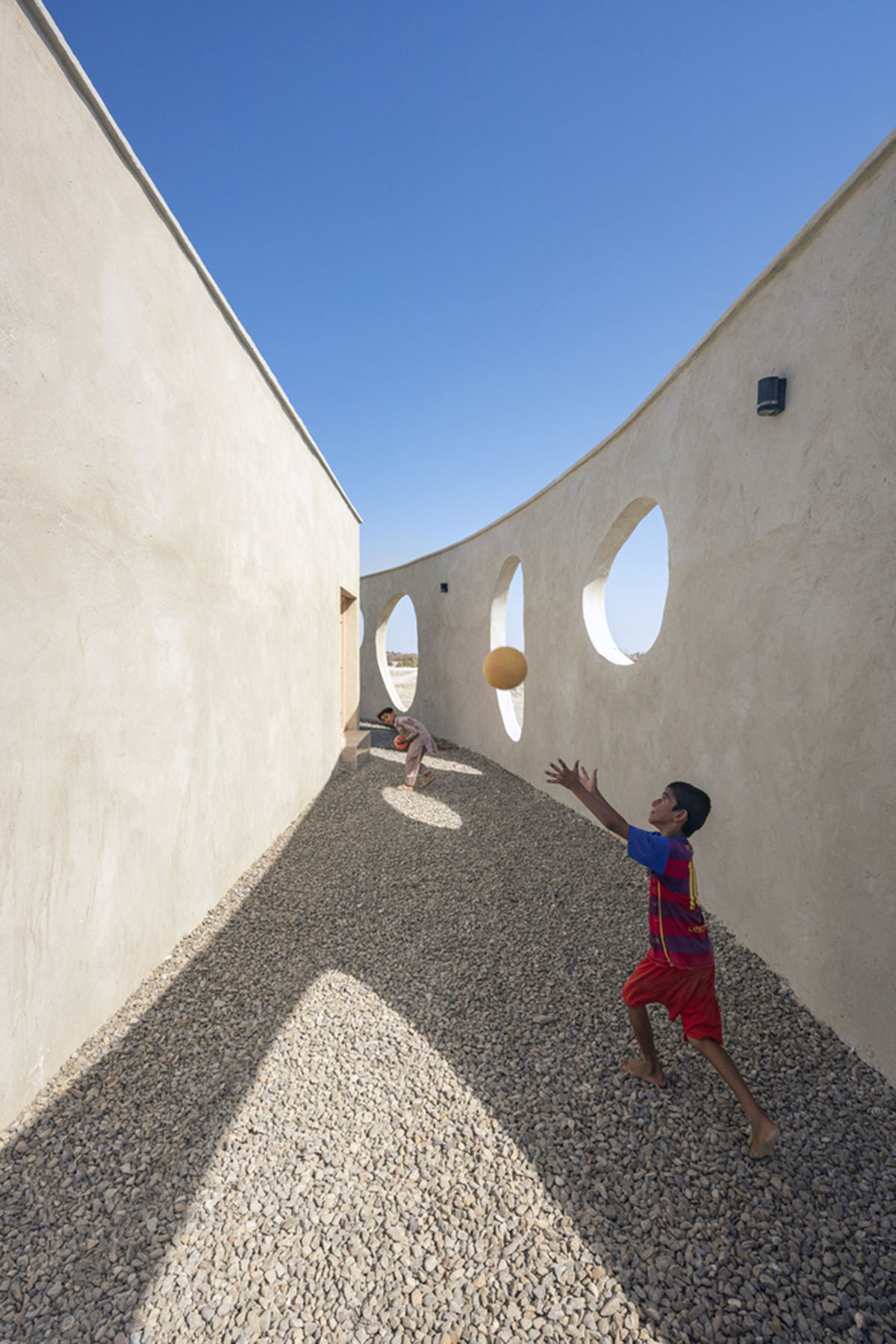 Circular wall featuring inhabitable holes encapsulates elementary school designed by Daaz Office