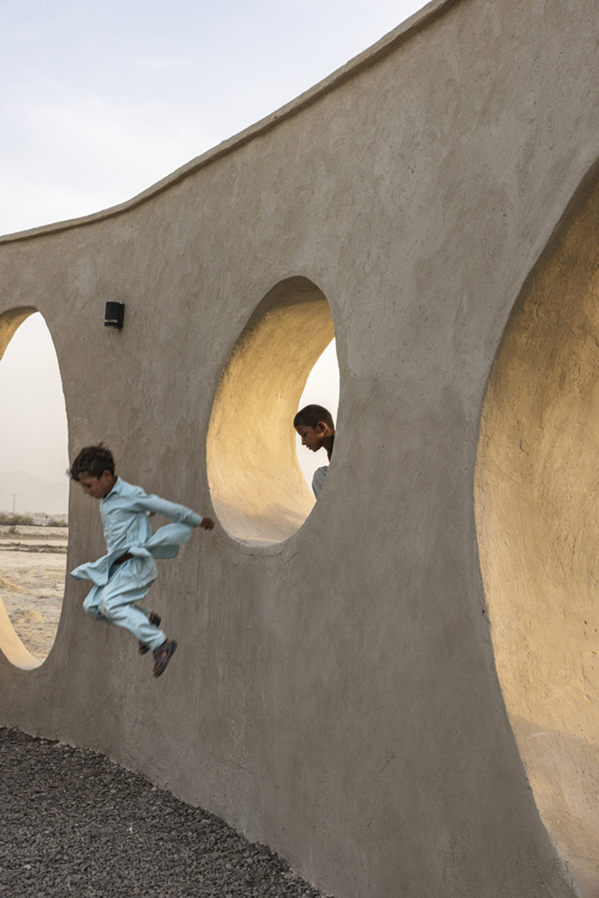 Circular wall featuring inhabitable holes encapsulates elementary school designed by Daaz Office