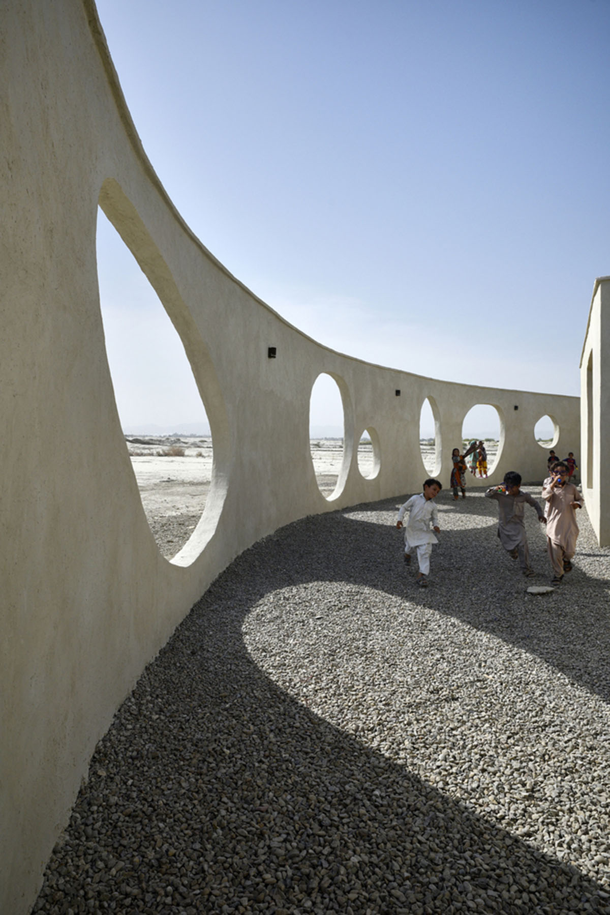 Circular wall featuring inhabitable holes encapsulates elementary school designed by Daaz Office