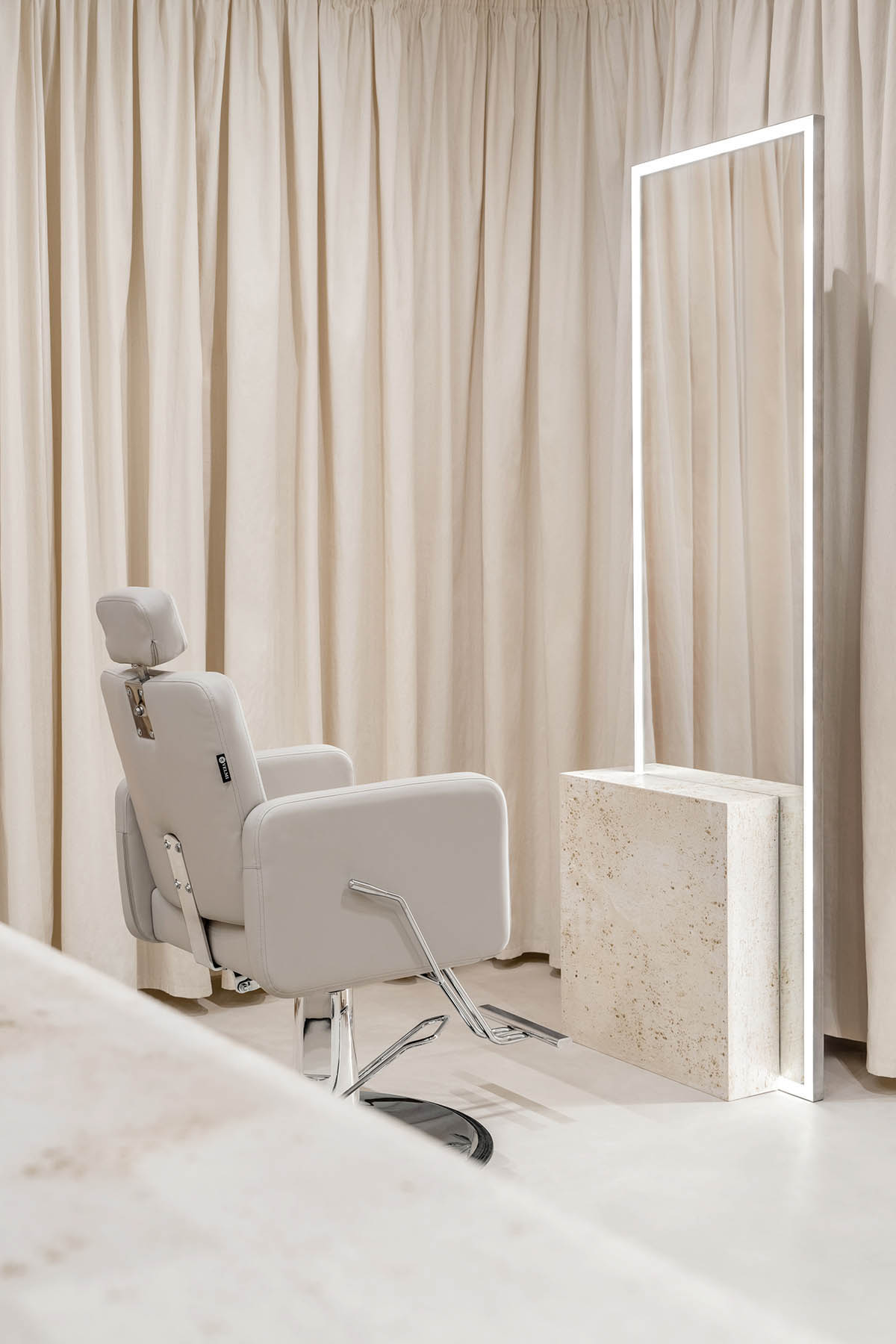 Tactile brick complements beige hues and mirrored surfaces for the interior of cosmetic showroom