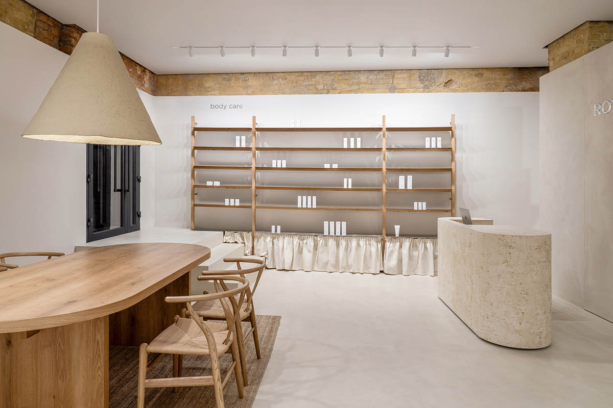 Tactile brick complements beige hues and mirrored surfaces for the interior of cosmetic showroom