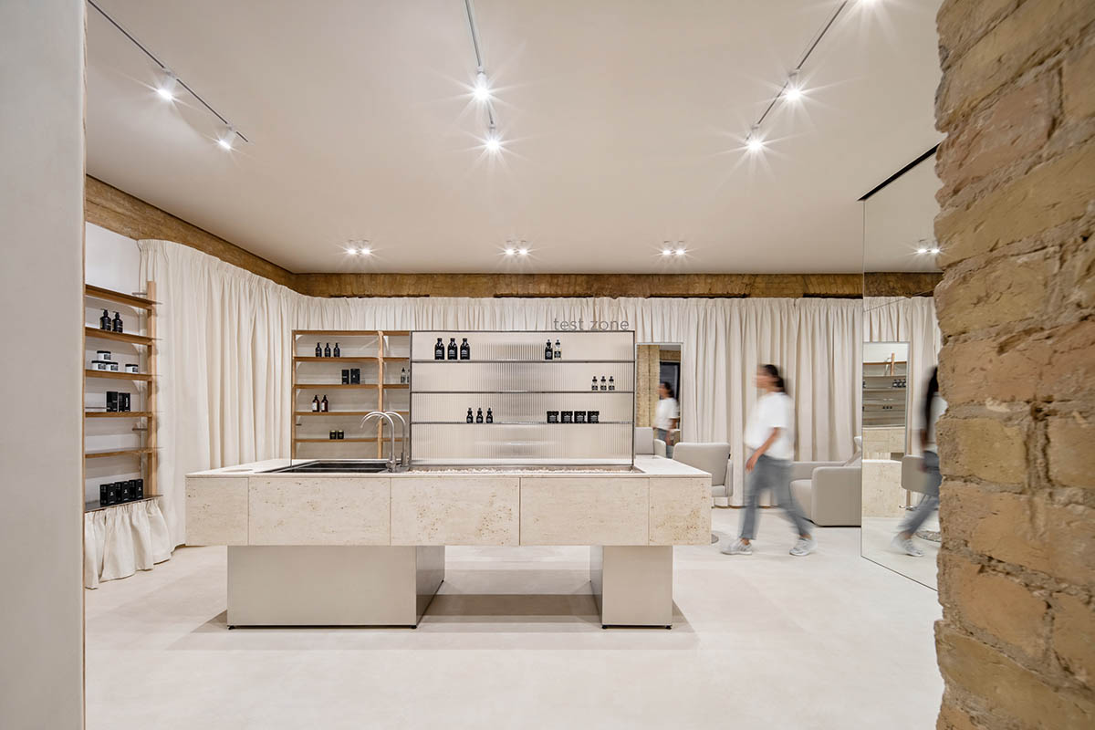 Tactile brick complements beige hues and mirrored surfaces for the interior of cosmetic showroom